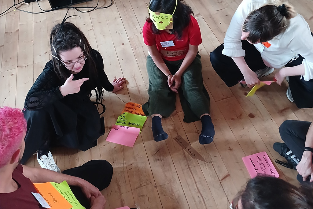 Group of 6 people sitting on the floor talking