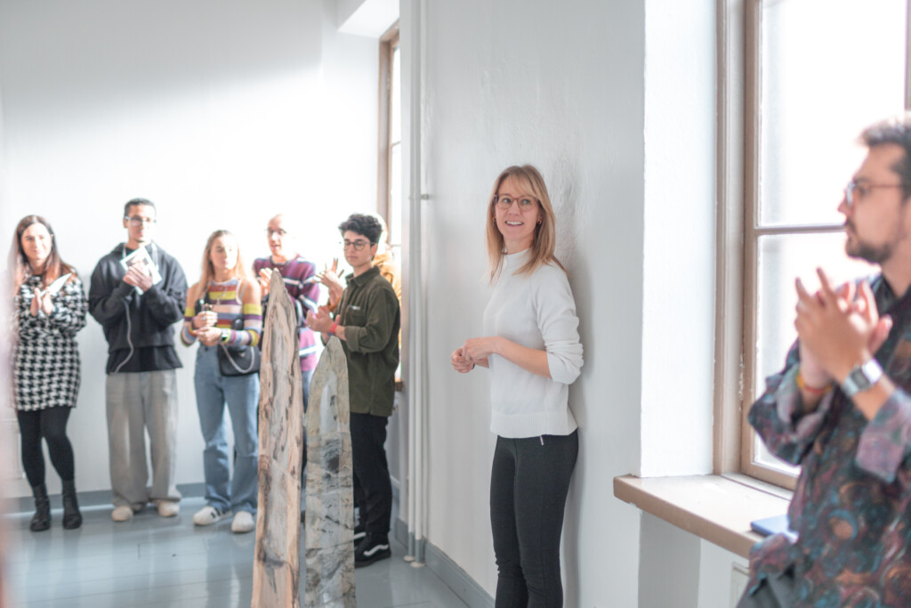 Group of people standing and talking in an art gallery with white walls
