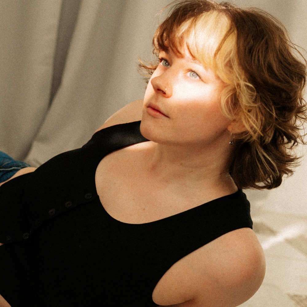 Headshot of a woman with sun reflection on her face