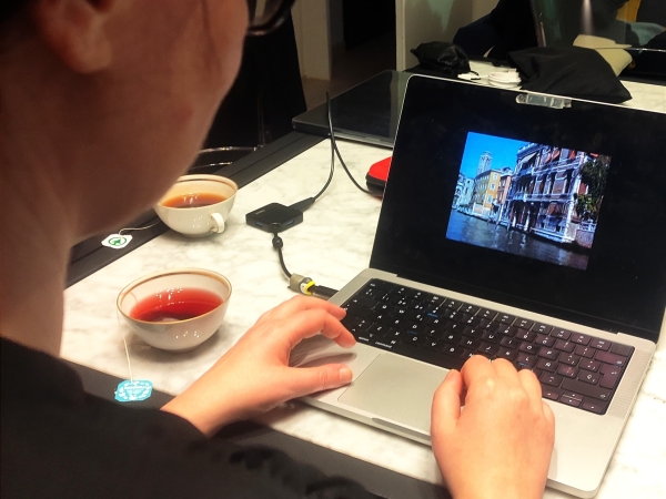 Person typing on a laptop with an image of Venice on the screen