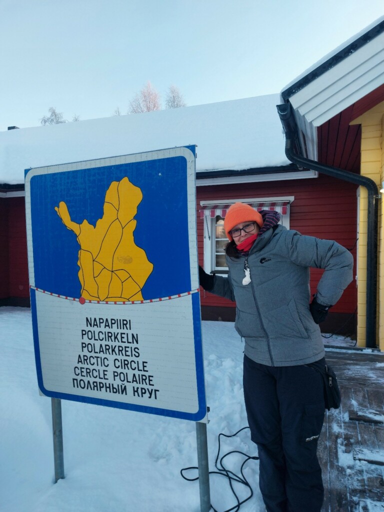 Person leaning to a North Pole sign